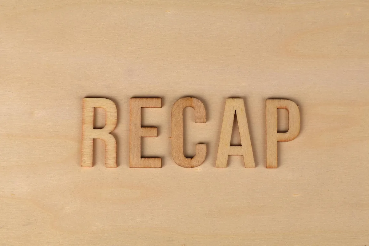 Wooden text reading "RECAP" engraved on a light wood surface