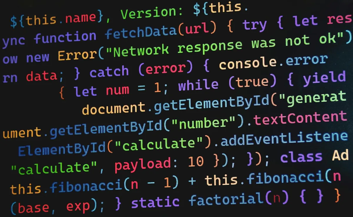 Close-up of colorful JavaScript code with syntax highlighting on a dark background, showing functions and variable declarations.