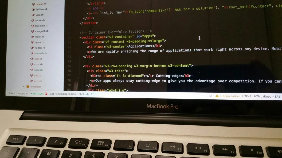 Developer working on Ruby on Rails code in text editor showing HTML template with applications section