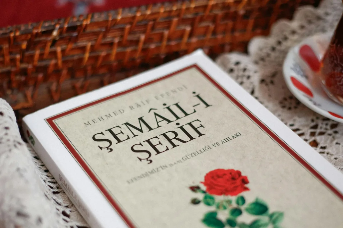 Turkish book "Şemail Şerife" by Mehmed Raif Efendi displayed on lace tablecloth with decorative items